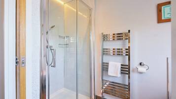 Une salle de bain moderne avec une douche à parois de verre, un porte-serviettes et des toilettes.