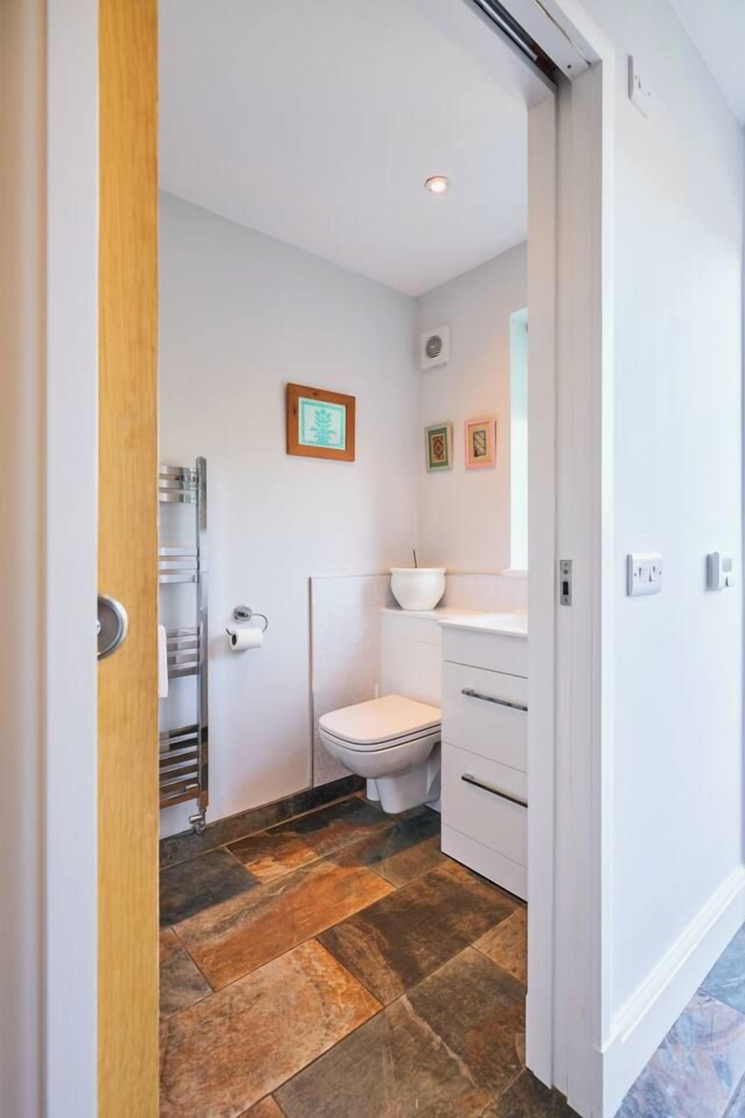 Ein Badezimmer mit Toilette, Waschbecken und Duschbereich.
