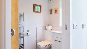 Ein Badezimmer mit Toilette, Waschbecken und Duschbereich.