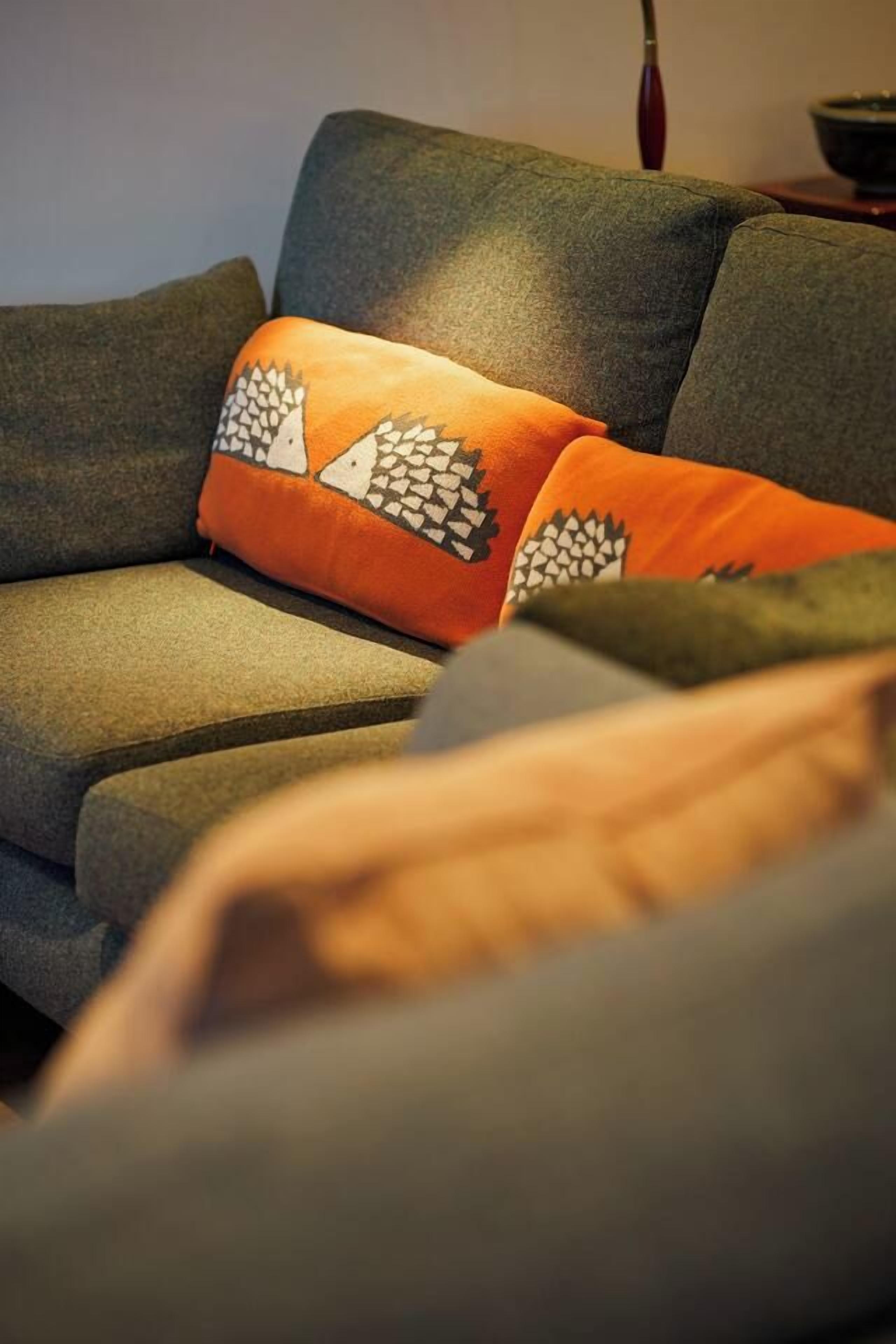 Un sofá gris con un cojín estampado.