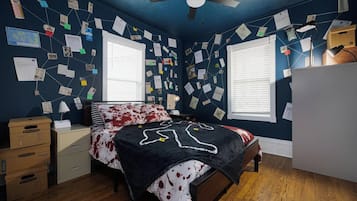 A bedroom with a bed, a nightstand, a dresser, a ceiling fan, and a window with blinds.