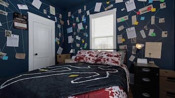A bedroom with a bed, a desk, and a wall covered with papers and notes.