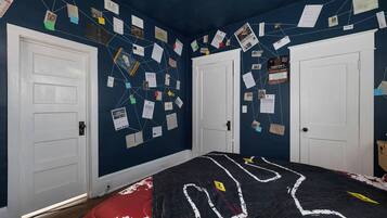 A bedroom with a bed, two white doors, and walls covered with various papers and notes.