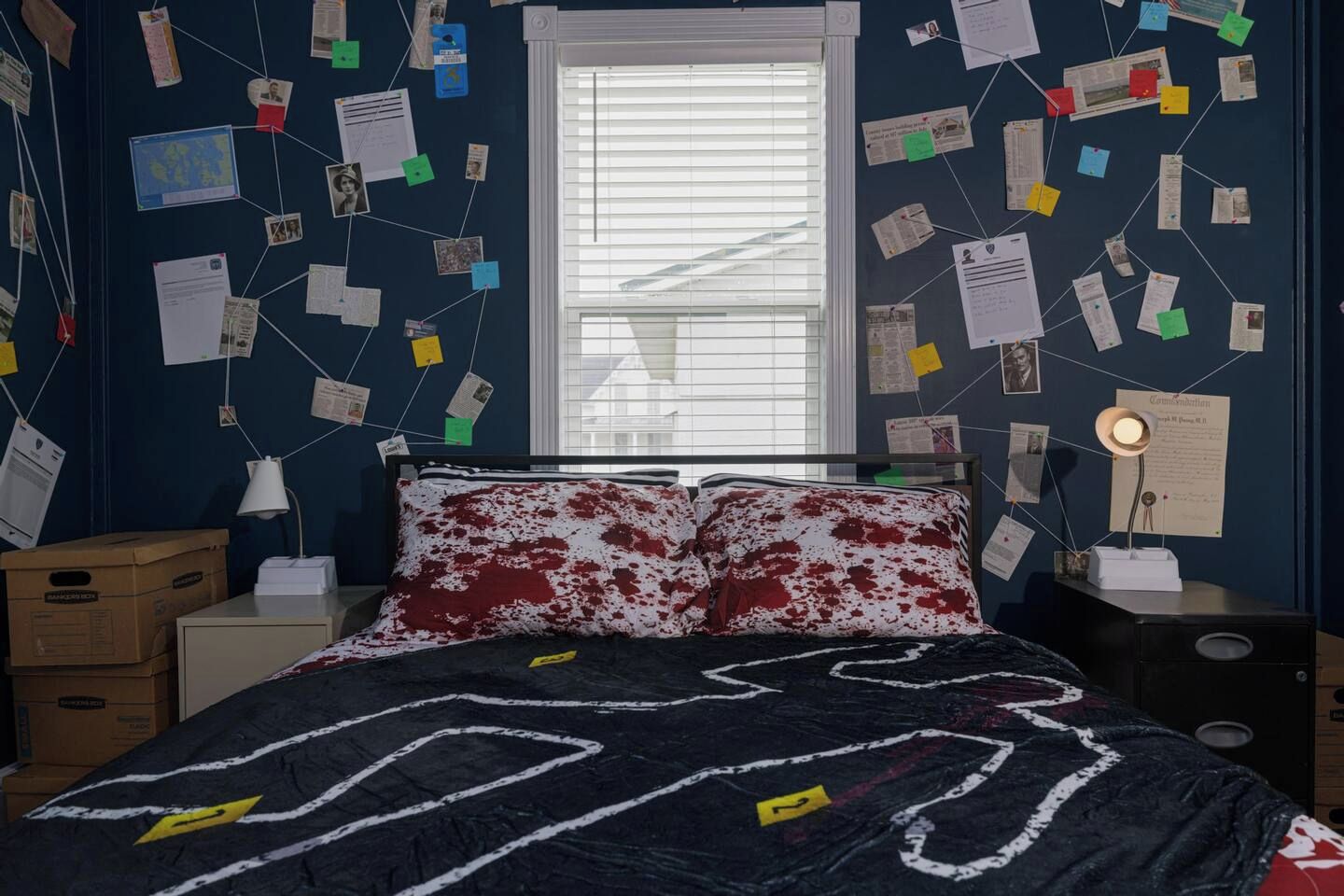 Un dormitorio con cama, ventana y pared decorada con notas e imágenes.