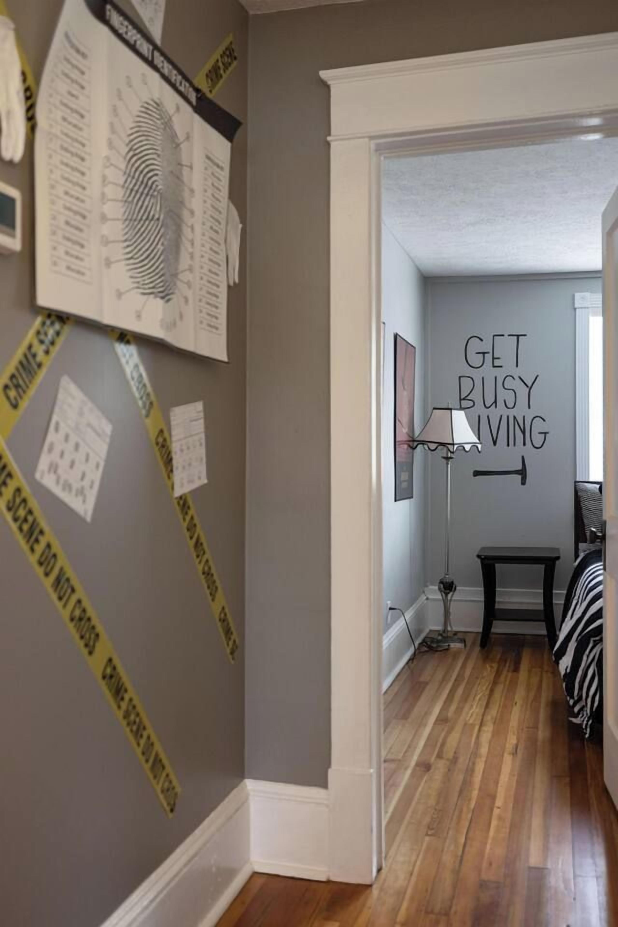A hallway with a wall-mounted sign that reads 'GET BUSY LIVING.'