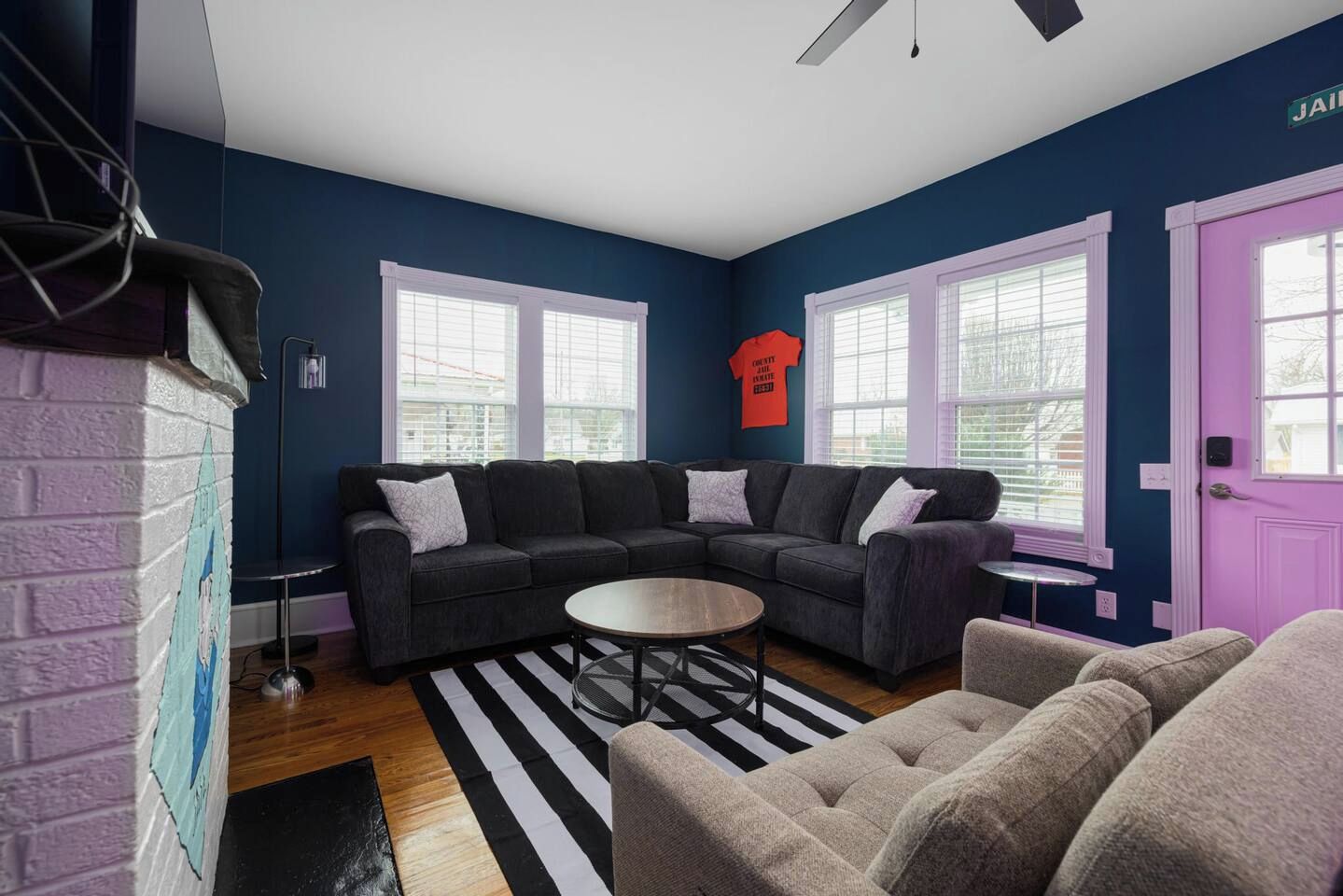 A living room with a sectional sofa, a round coffee table, and a striped rug.