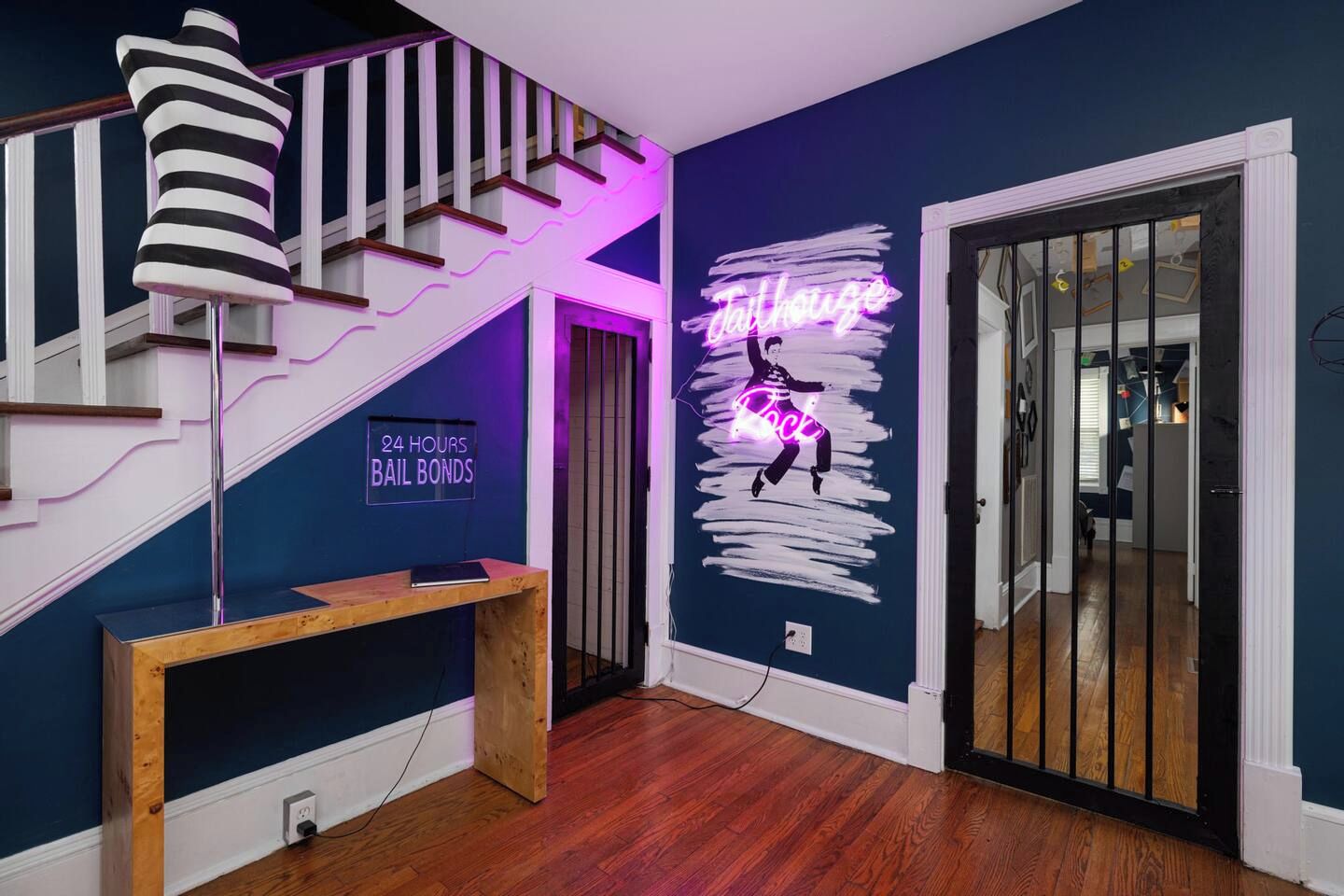 A staircase with a neon sign, a neon sign on the wall, and a wooden bench.