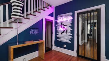 A staircase with a neon sign, a neon sign on the wall, and a wooden bench.