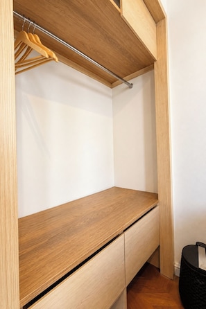 A wooden wardrobe with a hanging rod and a flat shelf.