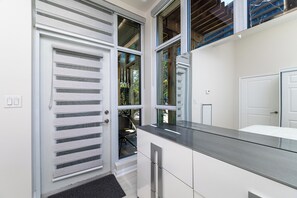 A modern kitchen with a built-in oven, a countertop, and a window with a view of the outdoors. - 2-Bedroom Condo Townhouse | Fort York & Lake Access (Toronto)