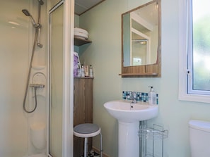 Une salle de bain avec une douche, un lavabo et des toilettes.