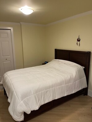 Ein Schlafzimmer mit einem Bett, einer Tür und einer Wanduhr.