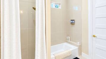Une salle de bain moderne équipée d’une douche, d’une baignoire et de toilettes.