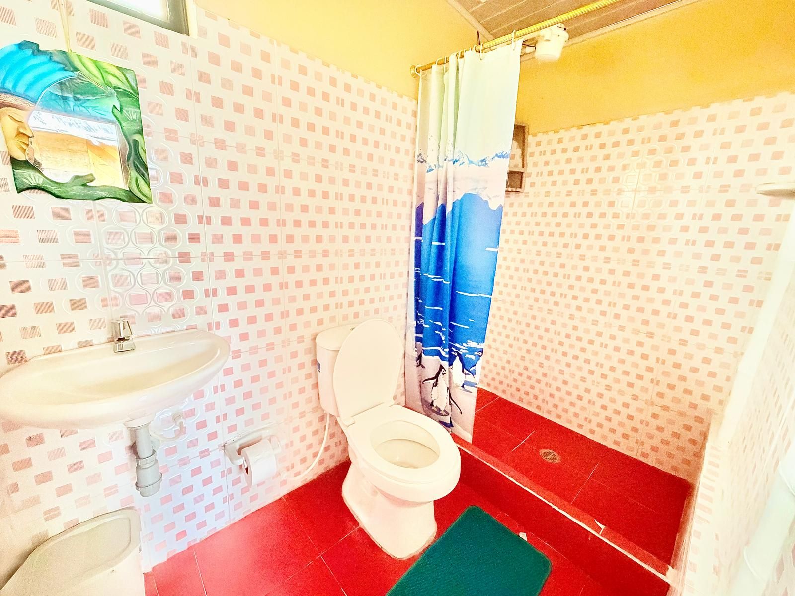 A bathroom with a toilet, sink, and shower curtain.