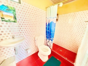 A bathroom with a toilet, sink, and shower curtain.