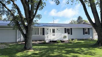 A single-story house with a porch, a garage, and a well-maintained lawn.
