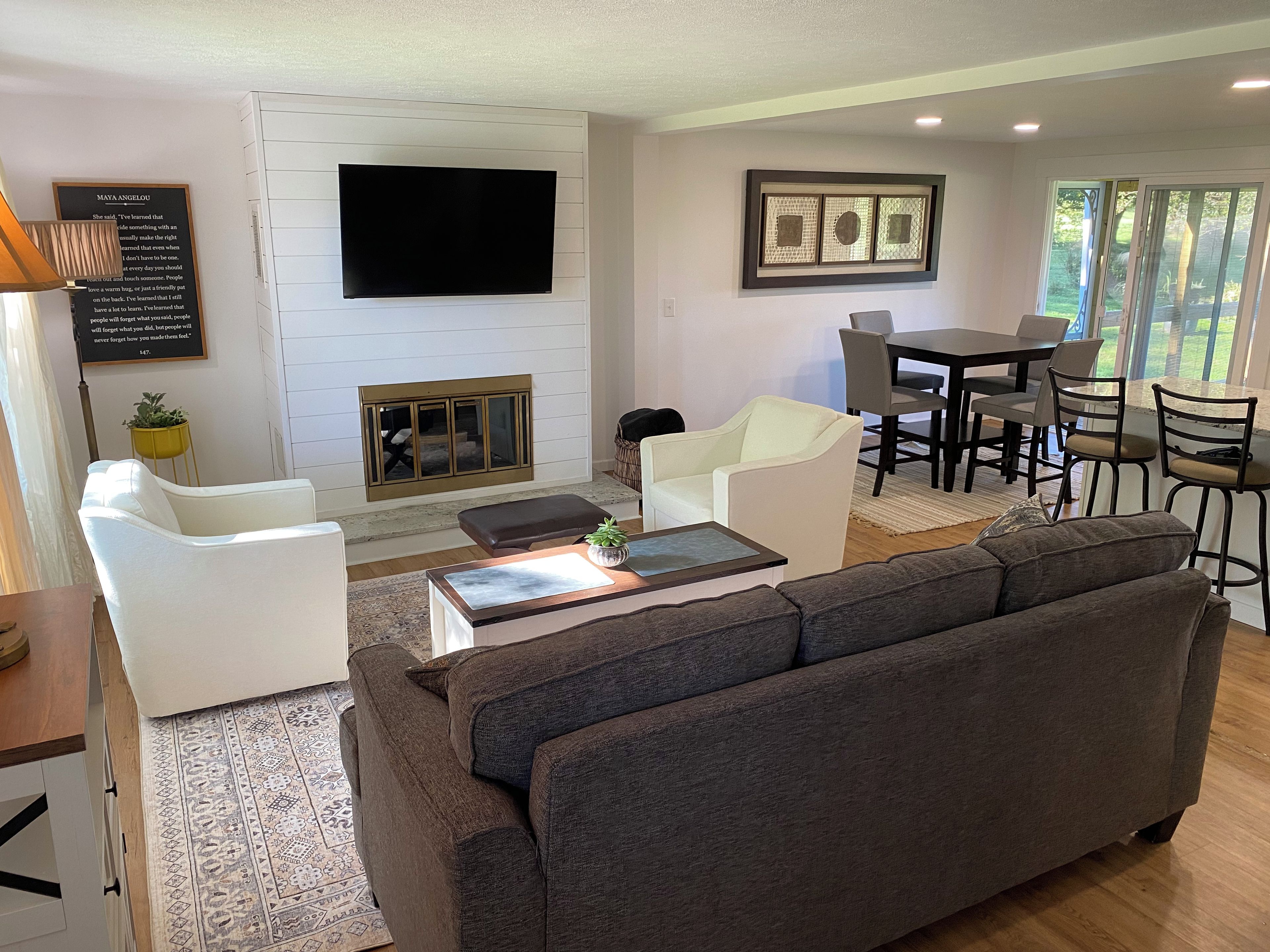 Un salon moderne avec un grand canapé, une table basse et un téléviseur à écran plat fixé au mur.