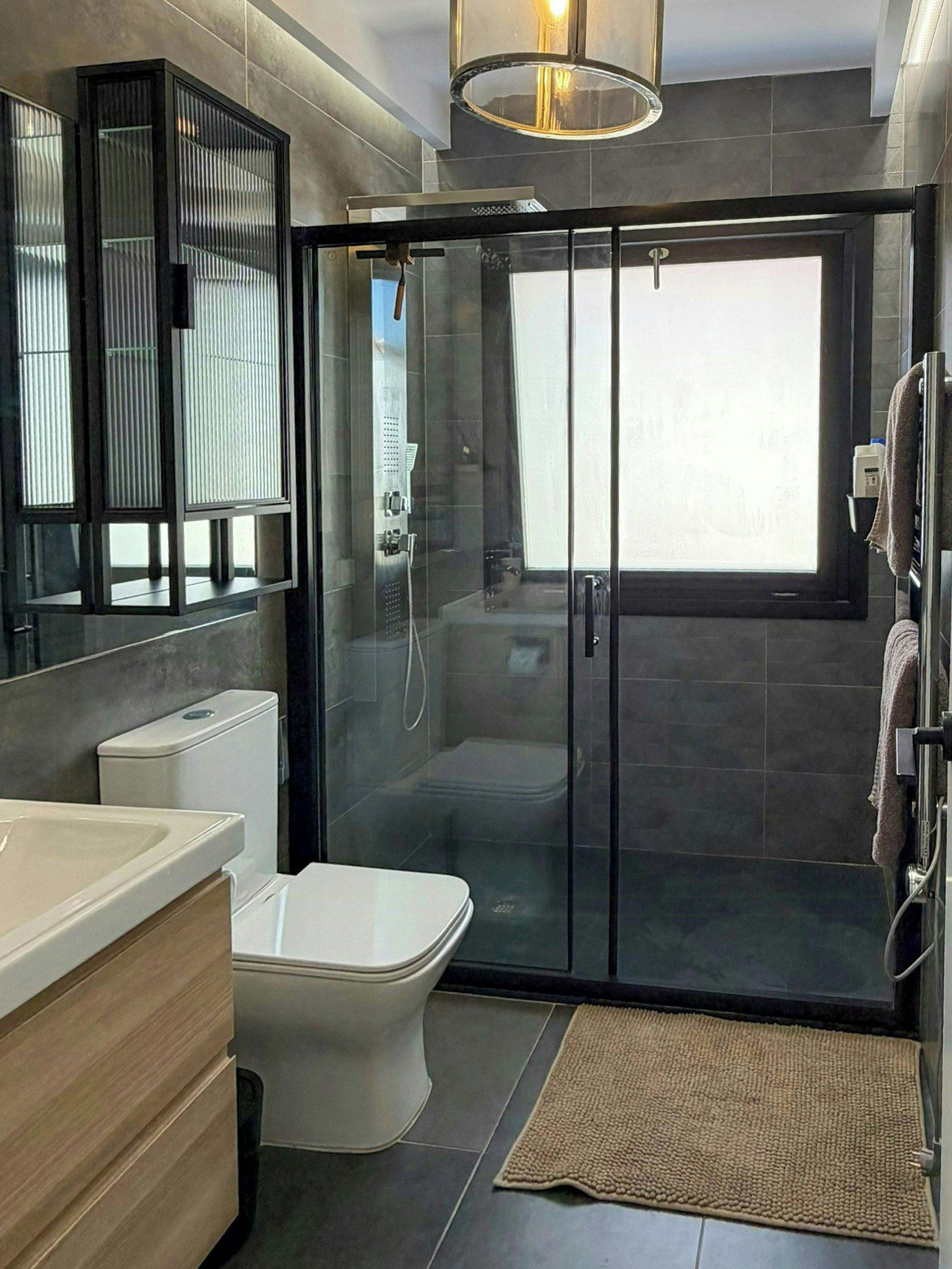 Un baño moderno con ducha de vidrio, inodoro y lavamanos.