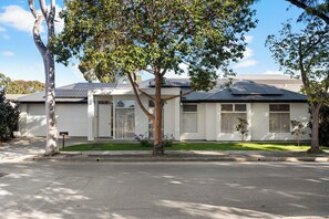 Ein modernes, zweistöckiges Haus mit Garage, Solaranlage und gepflegtem Rasen.