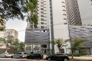 Un edificio de varios pisos con diseño moderno, que combina balcones y amplias ventanas.