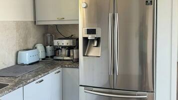 A stainless steel refrigerator with a water dispenser, a built-in ice maker, and a freezer compartment.