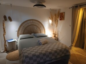 Un dormitori amb un llit gran, una taula de nit, una làmpada i una obra d'art penjada a la paret.