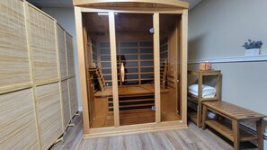 Quarto com guarda-roupa de madeira, um pequeno banco de madeira e prateleira com toalhas dobradas.
