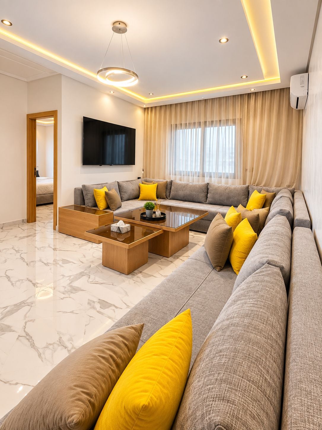 Una sala de estar moderna con un sofá modular, una mesa de centro y un televisor de pantalla plana.