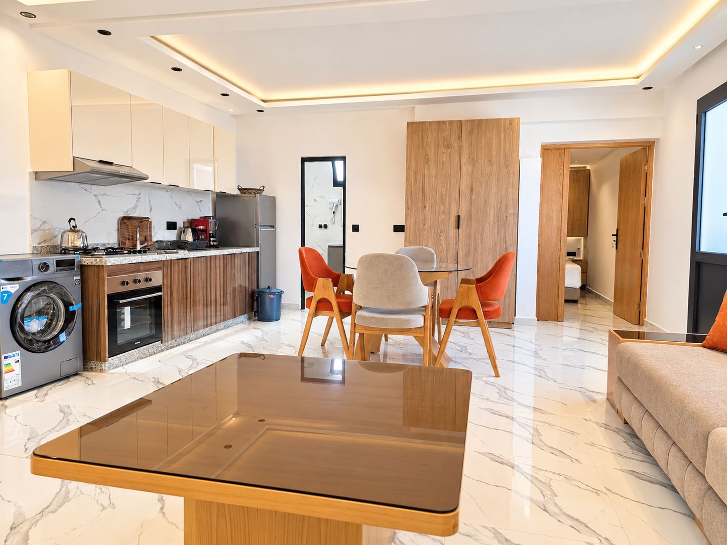 A modern apartment with a kitchen, dining area, and living room.