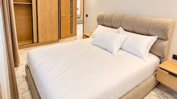 Una camera da letto moderna con un letto grande, un'armadio in legno e un comodino.