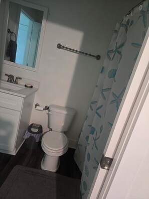 Ein Badezimmer mit Toilette, Waschbecken und Handtuchhalter.