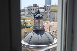 A view of a cityscape through a window, featuring a prominent building with a dome and a tower. - Palazzo De Sangro a Spaccanapoli, 3 camere (Naples)