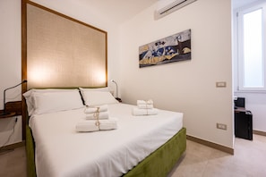 A hotel room with a bed, a headboard, a painting, and a window. - Picasso - The President, Stanza con un l · The President, Stanza con un letto picasso (Naples)
