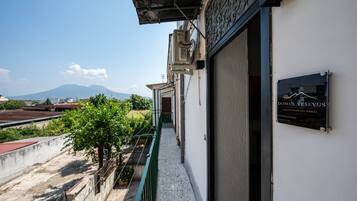Un edificio con un cartello che riporta 'DOMUS VESEVUS' e una vista di una montagna sullo sfondo.