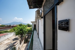 A building with a sign reading 'DOMUS VESEVUS' and a view of a mountain in the background. - 10 min dall'aeroporto - navetta - self check-in (Naples)