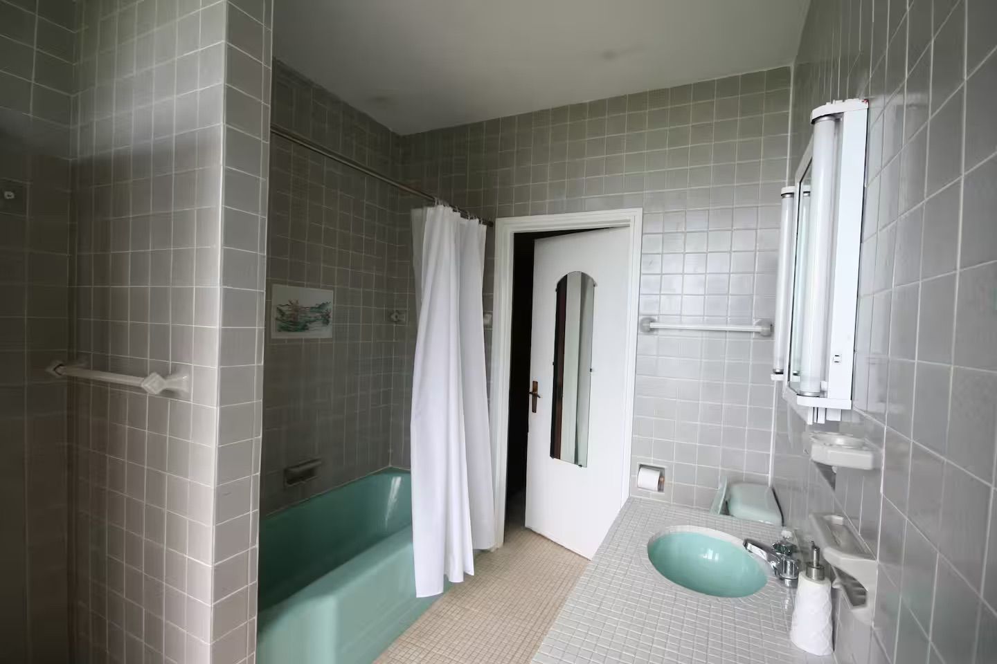 A bathroom with a bathtub, a sink, and a shower area.