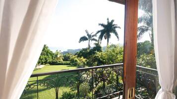 A balcony with a view of a golf course and palm trees.