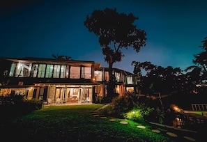 A two-story house with a large tree in the front yard. - Norse Hill Estate & Botanic Gardens (Port Antonio)