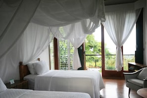 Ein Schlafzimmer mit zwei Betten, einem Nachttisch und einem Sessel.