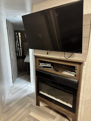 A modern entertainment unit with a flat-screen TV, a console table, and a built-in oven.