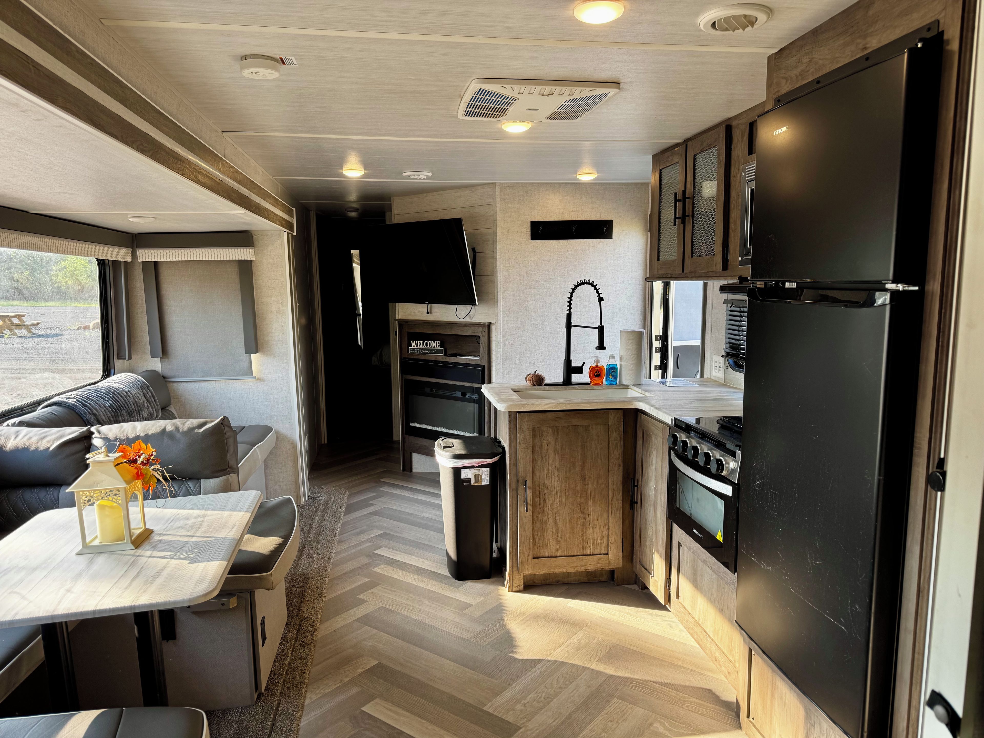 Cocina compacta para autocaravana con comedor, un lavamanos, estufa y refrigerador.