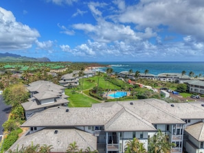 A coastal residential area with multiple buildings, a swimming pool, and a view of the ocean. - PS 126 - Ocean View • Near Shipwreck Beach (Poipu)