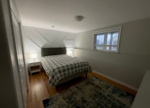 A bedroom with a bed, a nightstand, a window, and a ceiling fan. - Fenced in pet friendly 3 bedroom home (Stratford)