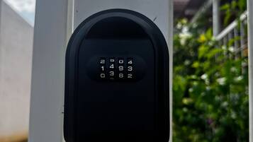 A keypad lock on a white post, likely for a mailbox or similar utility.