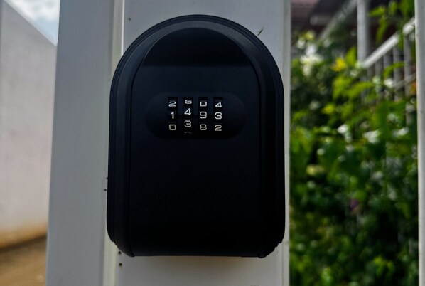A keypad lock on a white post, likely for a mailbox or similar utility. - Anáhuac Relaxation Room (Oax.)