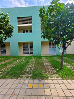 A building with a flat facade, multiple windows, and a paved area with numbered tiles. - Anáhuac Relaxation Room (Oax.)