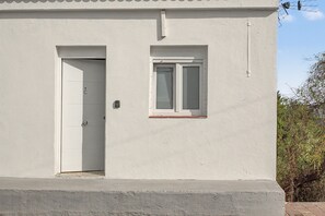 A white building with a single door and a window. - Vacation Apartment 'Paseo Por Las Nubes' with Wi-Fi and Air Conditioning (San José de los Llanos)