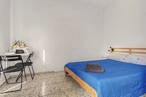 Une chambre à coucher avec un lit, un bureau et une chaise.