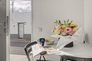 Une table avec un bouquet de fleurs, une tasse et un magazine.
