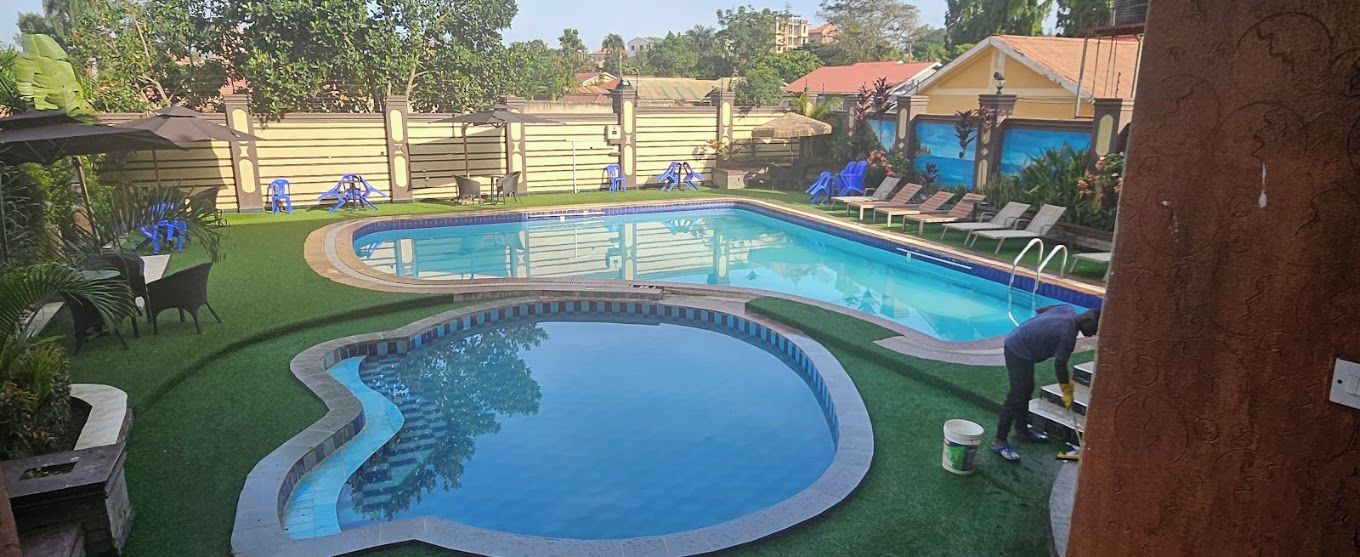Una piscina de diseño curvo, rodeada de césped y una valla.
